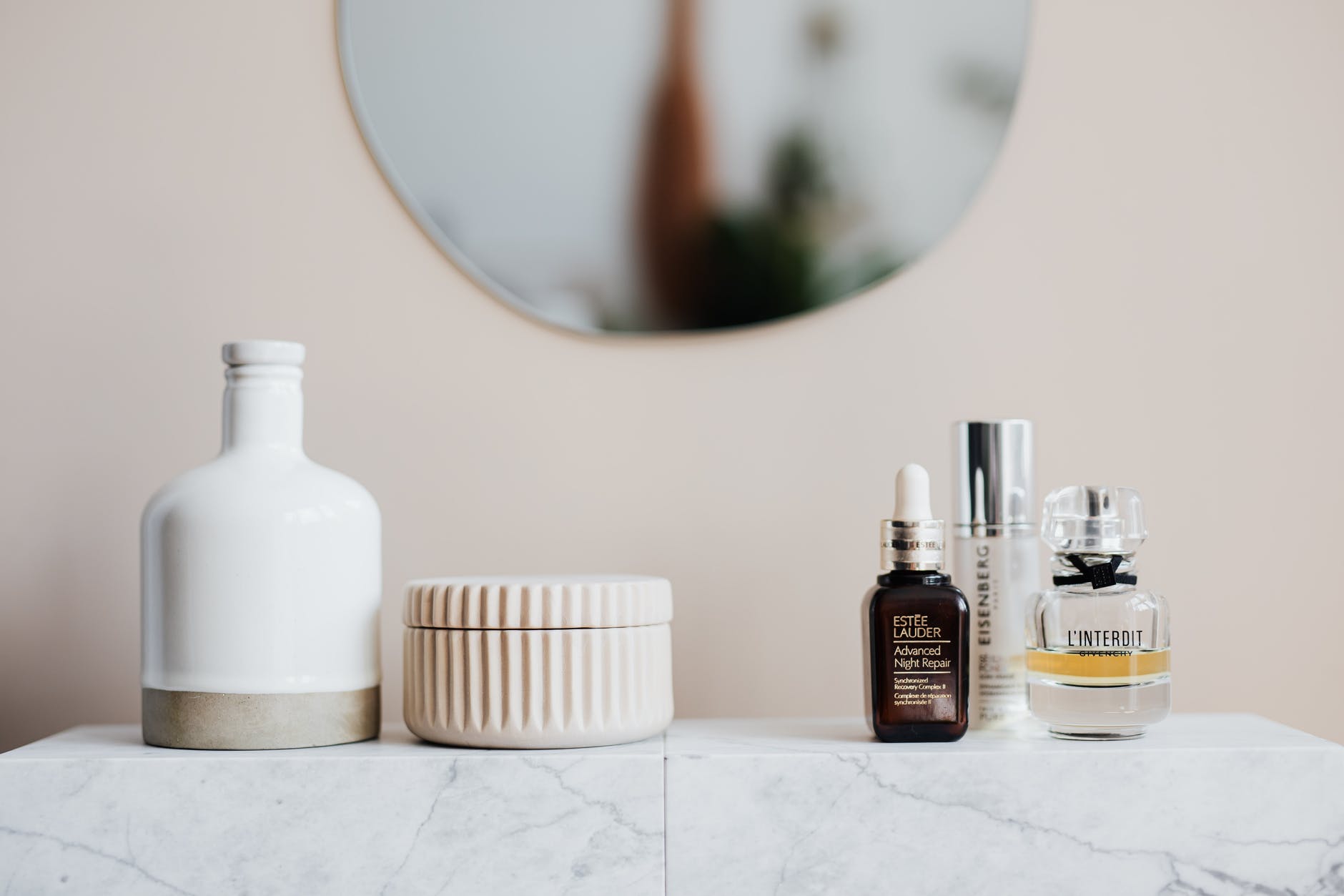 various beauty products on ceramic shelf in bathroom
