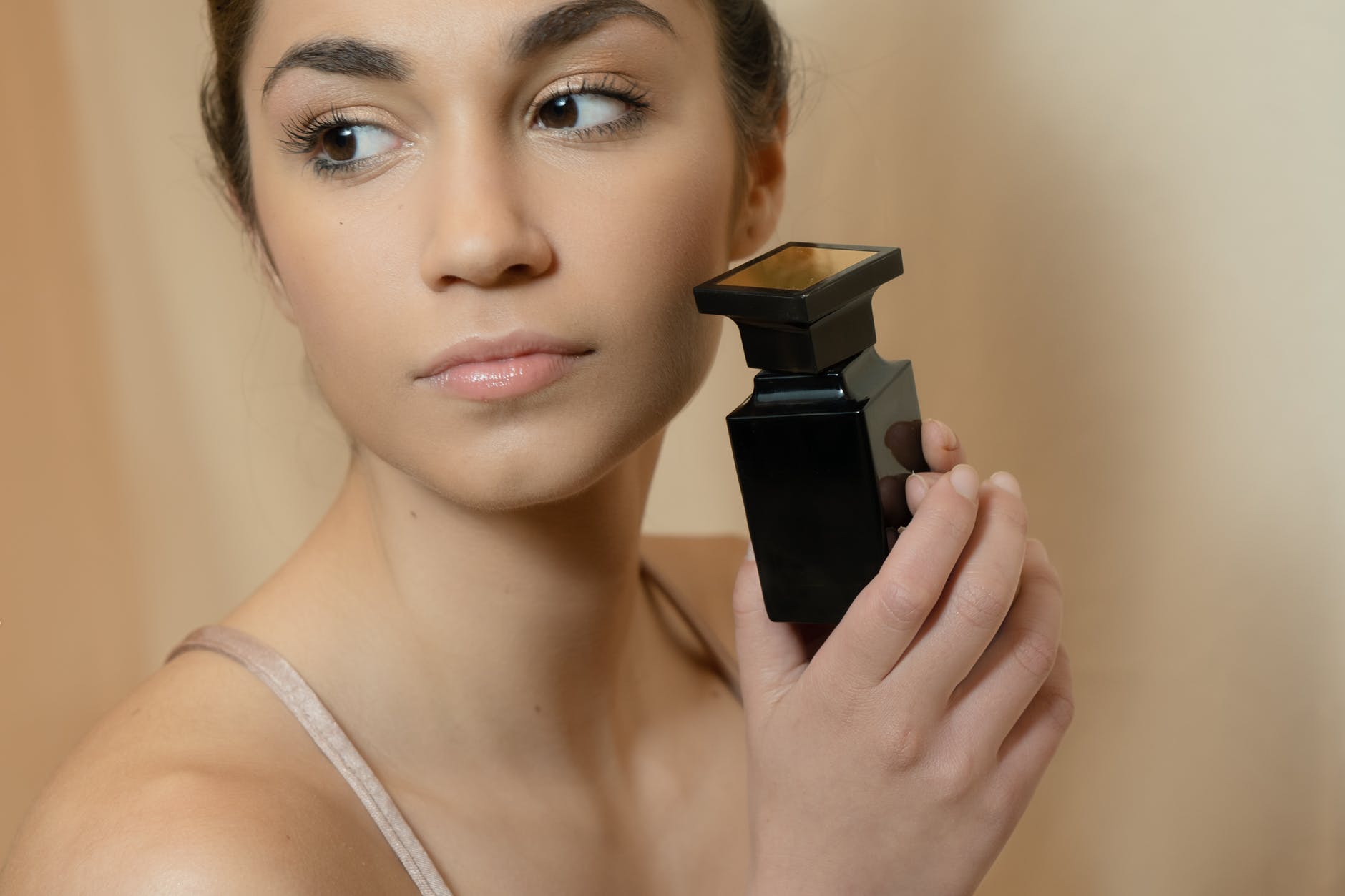 a woman holding a perfume bottle